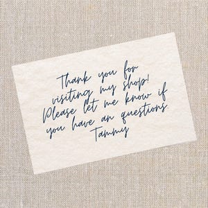 May include: A cream-coloured card with handwritten text in dark blue script. The text reads: "Thank you for visiting my shop! Please let me know if you have any questions. Tammy."