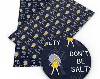 May include: Blue fabric with a repeating pattern of the text "Don't Be Salty" and a yellow umbrella with a person holding it. The text "Don't Be Salty" is also written in a larger font at the bottom of the fabric.