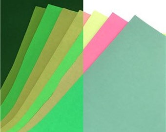 May include: Assortment of glow-in-the-dark paper sheets in various shades of green, yellow, and pink. The paper is arranged in a fan shape, with the darkest green sheet at the bottom and the lightest pink sheet at the top.