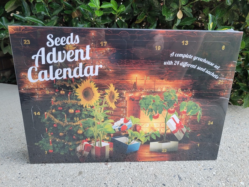 May include: Seeds Advent Calendar with a Christmas tree, sunflowers, and tomato plants. The calendar has 24 numbered windows and the text "A complete growhouse set with 24 different seed sachets."