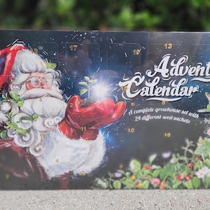 May include: Advent calendar featuring Santa Claus holding a sprouting plant. The calendar has a dark blue background with the words "Advent Calendar" in white script. It includes 24 seed packets for a complete greenhouse set.