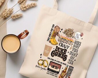 Puede incluir: Una bolsa de tela beige con un diseño de temática country. El diseño incluye un par de botas de vaquero, una cinta de casete, una botella de cerveza y el texto "Crazy Luke Combs, She Got The Best Of Me".
