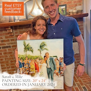 Könnte beinhalten: Ein Hochzeitsporträtgemälde, 51 cm x 61 cm, zeigt ein Paar und Hochzeitsgäste bei einer Zeremonie im Freien. Das Gemälde wird von einem lächelnden Paar gehalten. Der Text auf dem Gemälde lautet "Sarah & Mike" und "ORDERED IN JANUARY 2024".