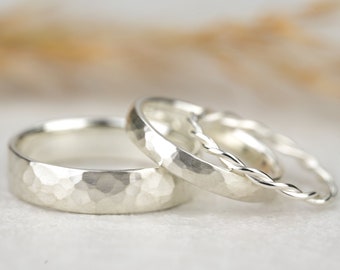 May include: Three silver rings, one with a hammered texture and two with a braided design.