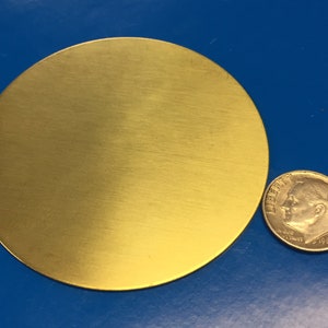 May include: A round, gold-colored metal disc. The disc is about the size of a US dime.