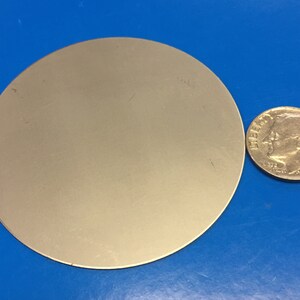 May include: A silver-colored metal disc, approximately the size of a US dime.
