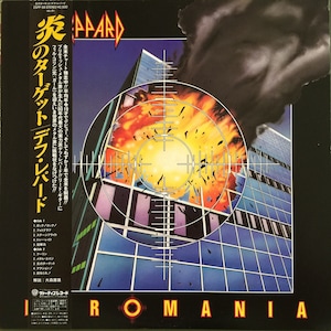 Könnte beinhalten: Ein Vinyl-Plattencover für das Album "Rommania" von Def Leppard. Das Cover zeigt ein Gebäude mit einer großen Explosion in der Mitte, umgeben von einer schwarzen Rauchwolke. Das Gebäude befindet sich im Zentrum eines Fadenkreuzes. Der Albumtitel "Rommania" ist in großen, fetten Buchstaben am unteren Rand des Covers gedruckt.