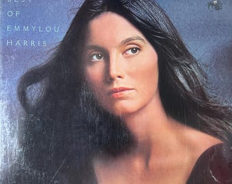 May include: Album cover for "Profile: Best of Emmylou Harris." The image features a portrait of Emmylou Harris with long, dark hair and a contemplative expression. The album title is printed in white text at the top.