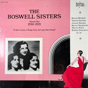 以下が含まれることがあります： 「The Boswell Sisters, Volume Two 1930-1935」のヴィンテージビニールレコードアルバムのカバー。カバーはピンク色で、黒い文字と姉妹の白黒写真が特徴です。アルバムにはスウィングミュージックが収録されています。
