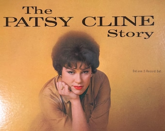 May include: A vinyl record album cover titled The Patsy Cline Story, a Deluxe 2-Record Set from MCA Records. The cover features a portrait of a person with dark hair, wearing a tan shirt, resting their chin on their hand against a yellow background.