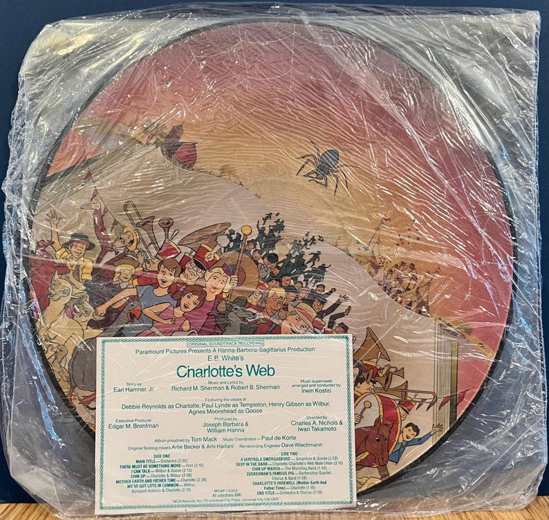 May include: A vintage record album cover for the movie Charlotte's Web. The cover features a colorful illustration of the characters from the movie, including Charlotte the spider, Wilbur the pig, and Templeton the rat. The album cover is in a plastic sleeve.