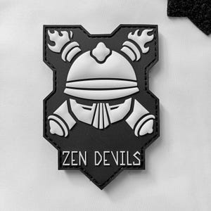 May include: Black and white patch with a stylized helmet design and the text "ZEN DEVILS".