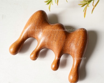 Könnte beinhalten: Ein Kamm aus Holz mit einem einzigartigen, abstrakten Design. Der Kamm hat eine glatte, braune Oberfläche und ist in Form einer Reihe fließender Kurven gestaltet.