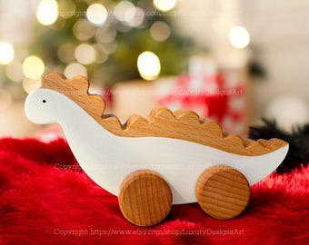 May include: A white and brown wooden toy dinosaur with wheels. The dinosaur has a long neck and tail, and its body is painted white with brown spots. The wheels are made of wood and are painted brown.