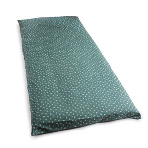 May include: A long, rectangular floor cushion in teal, patterned with small, off-white shapes. The cushion is designed for floor use, offering a comfortable seating or lounging option. Measures approximately 180cm in length.
