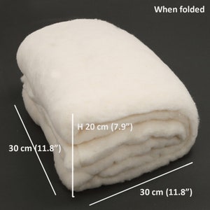 K&ouml;nnte beinhalten: Ein gefalteter, cremewei&szlig;er Textilartikel mit weicher, flauschiger Textur. Der Text 'When folded' erscheint in der oberen rechten Ecke. Die Ma&szlig;e sind mit 30 cm mal 30 cm mal 20 cm angegeben, mit H 20 cm (7.9") und 30 cm (11.8").