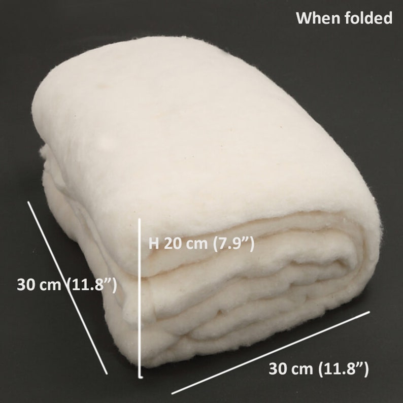 K&ouml;nnte beinhalten: Ein gefalteter, cremewei&szlig;er Textilartikel mit weicher, flauschiger Textur. Der Text 'When folded' erscheint in der oberen rechten Ecke. Die Ma&szlig;e sind mit 30 cm mal 30 cm mal 20 cm angegeben, mit H 20 cm (7.9") und 30 cm (11.8").