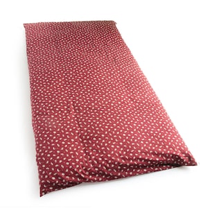 May include: A rectangular, burgundy floor cushion featuring a repeating pattern of small, white, irregular shapes. The cushion is made of a soft fabric. It is designed for comfort and support. Ideal for meditation or relaxation, it measures approximately 180cm in length.