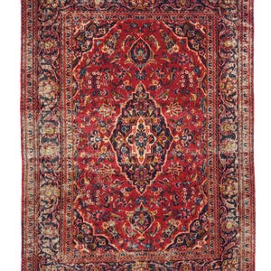 May include: A rectangular, antique Persian rug with a central medallion design. The rug features a deep red field with intricate floral patterns in navy, blue, and cream. The border is a darker navy with similar floral motifs.