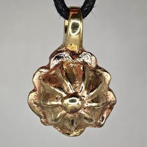 Medieval amulet in the form of a flower. Medieval artifacts. Medieval pendant. Medieval amulet. Medieval jewelry. Medieval pendant.