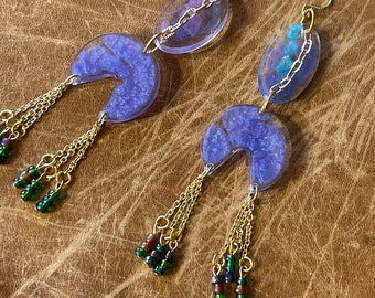Handmade resin earrings in purple and blue! Swirls of purple and blue pigments in clear resin pieces with gold chain details!