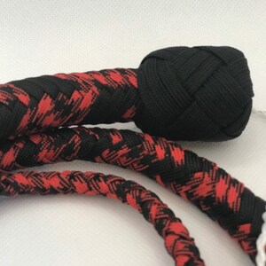 May include: A black and red braided whip with a black braided knot at the end.