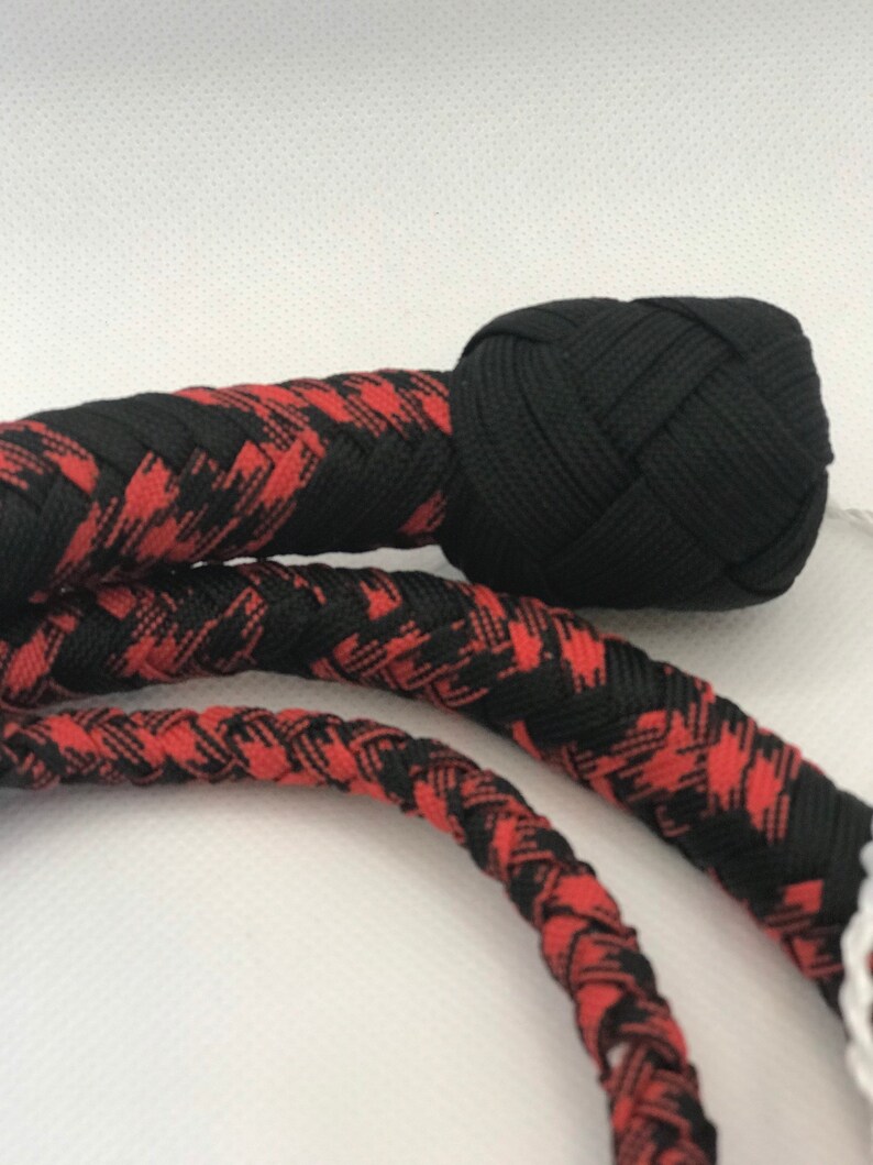 May include: A black and red braided whip with a black braided knot at the end.