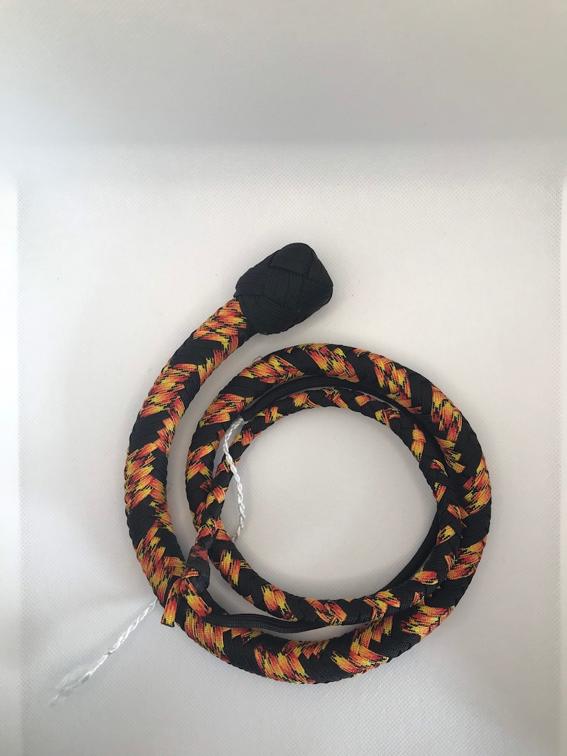 May include: A black and orange braided whip with a black knotted handle.