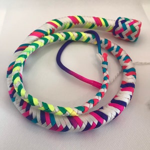 May include: A colorful braided whip with a white background and a rainbow of colors including pink, blue, green, and yellow.