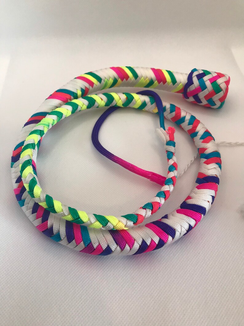 May include: A colorful braided whip with a white background and a rainbow of colors including pink, blue, green, and yellow.