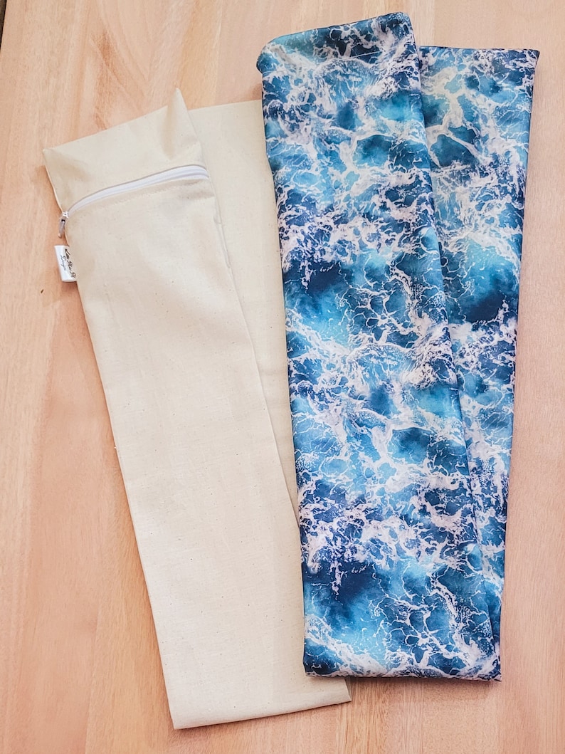 May include: Two fabric pouches, one is plain beige with a zipper, the other is blue with a white wave pattern.