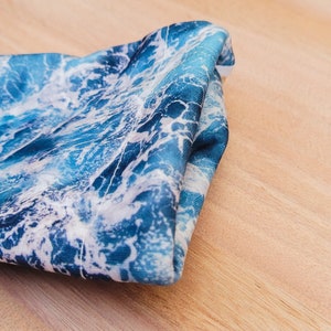 May include: A folded blue and white fabric with a wave pattern.