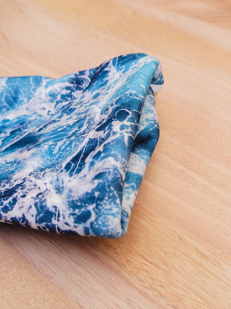 May include: A folded blue and white fabric with a wave pattern.