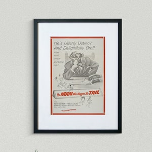 May include: A black and white movie poster for the film "The Man Who Wagged His Tail". The poster features a drawing of Peter Ustinov in a suit and tie, sitting at a desk with a phone in his hand. The text on the poster reads "He's Utterly Ustinov And Delightfully Droll".