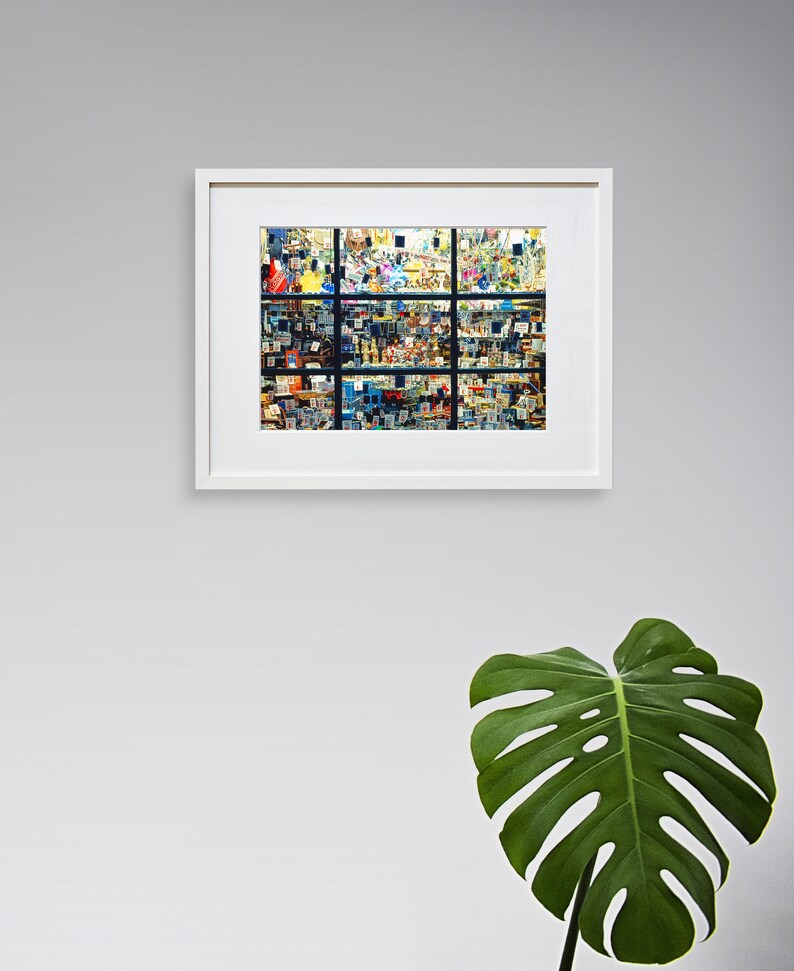May include: A framed photograph of a colourful, abstract, geometric pattern. The pattern is made up of many small squares and rectangles, creating a sense of depth and movement. The frame is white and has a simple, modern design.