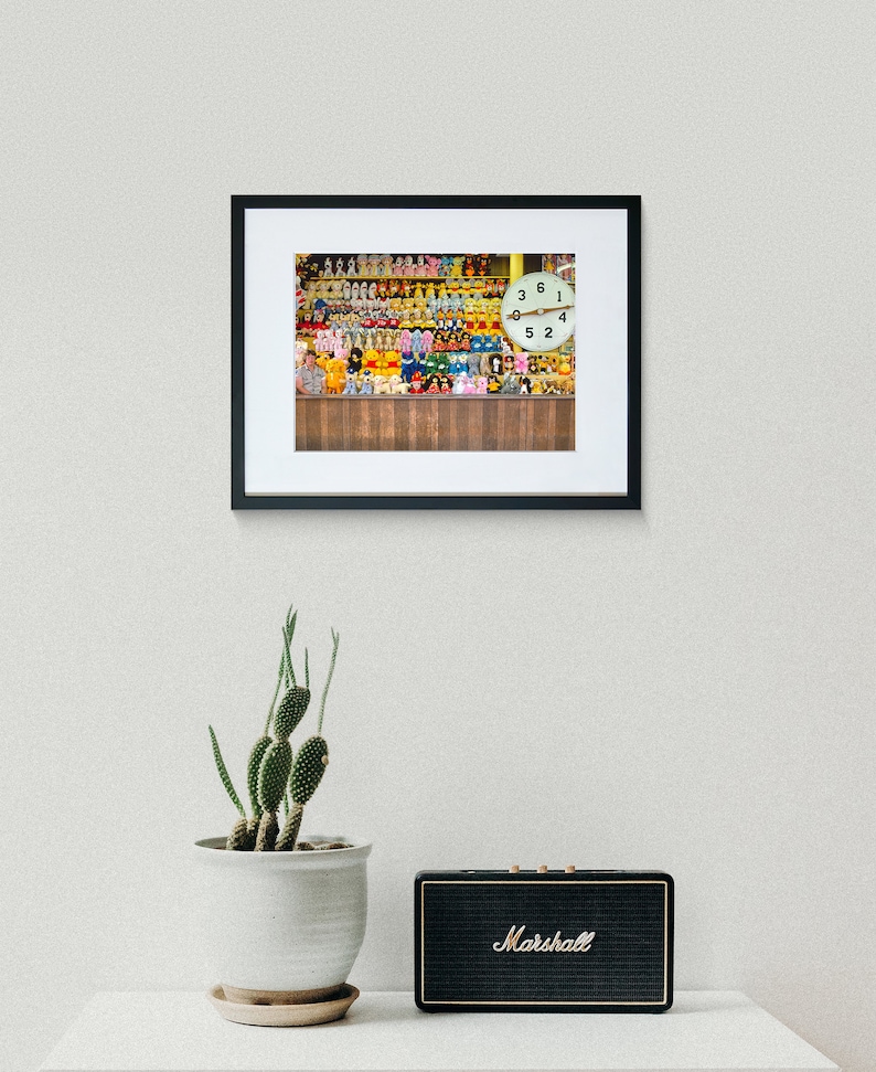 May include: A framed photograph of a wall filled with colorful stuffed toys and a clock with the numbers 3, 6, 1, and 4 visible.