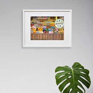 May include: A framed photograph of a wall filled with colorful stuffed animals and a clock with the numbers 3, 6, 1, 9, 4, 5, and 2.