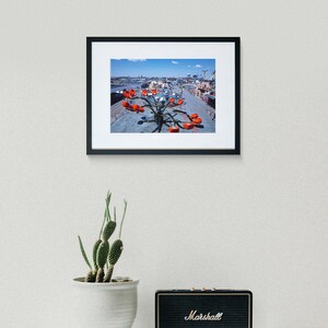 May include: A framed photograph of a red and silver amusement park ride with a blue sky in the background.