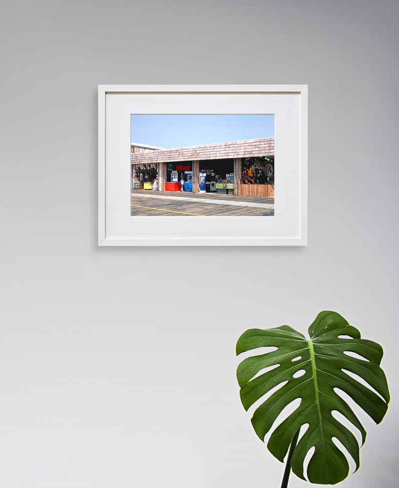 Pode incluir: Uma fotografia emoldurada de uma vitrine com uma marquise vermelha, azul e verde. A vitrine tem v&aacute;rias janelas e uma placa que diz "Bem-vindo".