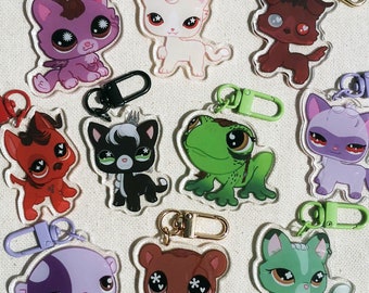 May include: A set of ten colorful keychains featuring cartoon animal characters. The keychains are made of clear acrylic and feature a variety of animals, including a cat, a dog, a frog, and a bear. The keychains are perfect for adding a touch of personality to your keys or bag.