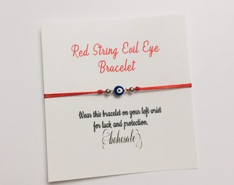 May include: Red string bracelet with a blue evil eye charm. The card reads "Red String Evil Eye Bracelet. Wear this bracelet on your left wrist for luck and protection.  #bohosale"