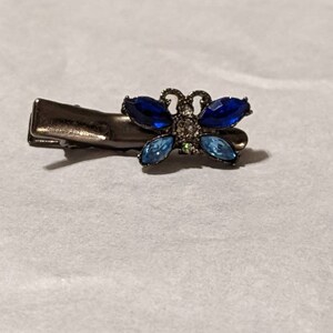 May include: A silver butterfly hair clip with blue and light blue rhinestones.