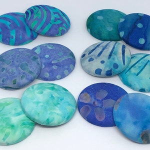 May include: Ten round fabric buttons in shades of blue and green with various batik patterns.