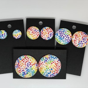 Peut inclure: Trois paires de boucles d'oreilles à pois arc-en-ciel sur des cartes d'affichage noires. Les boucles d'oreilles sont de tailles différentes, la plus grande paire mesurant environ 3,8 cm de diamètre.