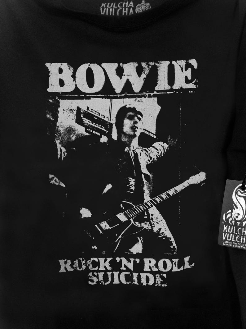 May include: Black and white graphic t-shirt featuring a silhouette of David Bowie playing guitar with the text "BOWIE" above and "ROCK 'N' ROLL SUICIDE" below the image.