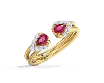 May include: A gold ring featuring two pear-shaped, deep red gemstones, each surrounded by a halo of small, clear diamonds. The ring's band is a double-layered design, creating a unique and elegant look. The gemstones are set in a way that they appear to float.