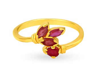 May include: A gold ring featuring a cluster of five marquise-cut, deep red gemstones. The ring's band and setting are a bright, polished gold, creating a striking contrast with the red stones. The gemstones are arranged to resemble a floral design.
