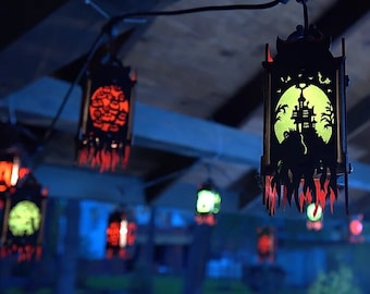 May include: A collection of black lanterns with intricate cut-out designs. The lanterns are illuminated with green and red lights, creating a spooky and festive atmosphere.