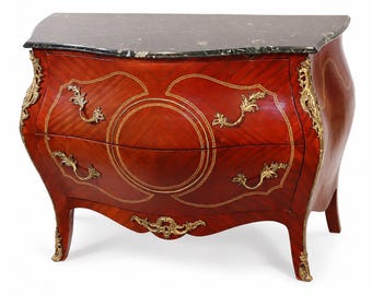 May include: A bombe chest of drawers featuring a dark green marble top, reddish-brown wood veneer with light wood inlay patterns, and ornate gold-toned metal hardware including decorative handles and corner mounts on four curved legs.