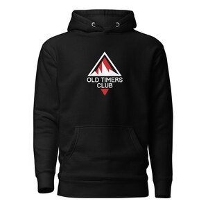 May include: Black hoodie with a front pocket and a drawstring hood. The front features a white triangle with a red mountain design and the text "OLD TIMERS CLUB" in white.